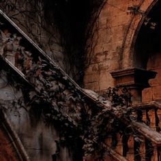 an old building with vines growing on the outside wall and balcony railings in front of it