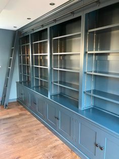 an empty room with blue bookcases and wooden floors