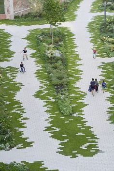 several people walking down a path made out of squares and grass in the shape of rectangles