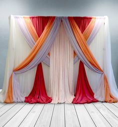 an orange, white and pink drape draped over a wooden floor