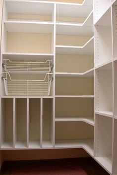 an empty closet with white shelving and shelves