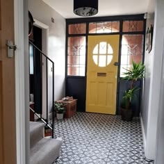 a yellow door is in the middle of a black and white tile floored hallway