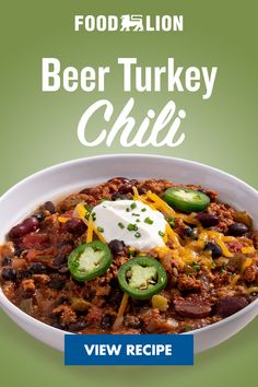 a white bowl filled with chili and cheese on top of a green background, text reads food lion beer turkey chili view recipe