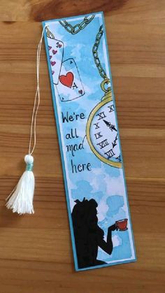 a bookmark with a tassel hanging from it's side on a wooden table