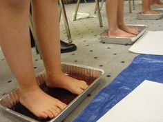 two people standing in tin pans on the floor with their feet propped against each other