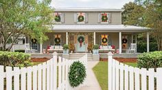 a house decorated for christmas with wreaths on the front door and decorations on the porch