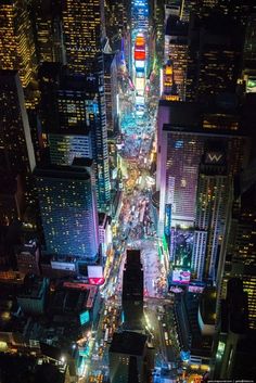 an aerial view of the city at night from high up in the sky, looking down on traffic and skyscrapers