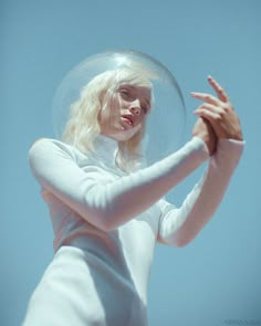 a woman with blonde hair is holding a clear bubble