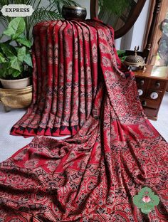 Update! - Zynah covered by LBB - https://lbb.in/bangalore/zynah-designs-handloom-sarees/ Collection: Daastaan-e-Ajrakh Transform your style with our Madder Red Ajrakh Modal Silk Saree. Immerse yourself in the rich heritage of hand block printing and eco-conscious fashion. Crafted with 100% natural dyes, this saree is a masterpiece of tradition and sustainability. Make a statement with elegance. Shop now for an exquisite addition to your wardrobe. About The Craft: Ajrakh Craft, rooted in Gujarat and Rajasthan, India, is a heritage-rich textile tradition celebrated for its intricate hand block printing and 100% natural dyes. Derived from "Azrak," meaning blue, the craft boasts a stunning range of colors and symmetrical patterns. Artisans meticulously carve wooden blocks to create detailed de Red Bohemian Chanderi Blouse Piece, Red Kalamkari Print Traditional Wear In Cotton Silk, Red Cotton Silk Traditional Wear With Kalamkari Print, Red Chanderi Blouse Piece With Block Print, Red Cotton Silk Blouse Piece With Kalamkari Print, Red Cotton Silk Saree With Kalamkari Print, Red Bohemian Blouse Piece With Bandhani Print, Traditional Long Sleeve Kalamkari Saree, Unstitched Red Blouse Piece With Kalamkari Print