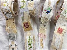 several pieces of fabric with flowers and laces on them sitting on a white table cloth