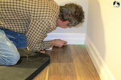 a man is laying on the floor with his hands in the corner and looking down