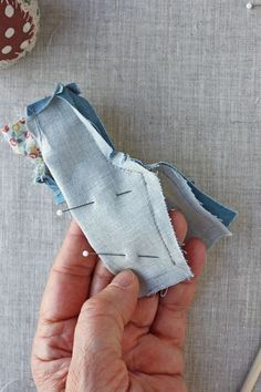 someone is stitching the fabric on top of an old piece of cloth to make a bird ornament