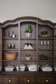 an old china cabinet with many dishes on it