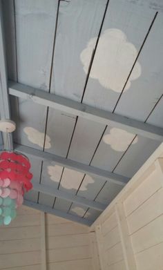 the ceiling is painted with white clouds and pink, blue, and green circles on it