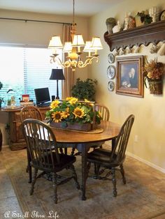 a dinning room table with sunflowers in the center and pictures on the wall