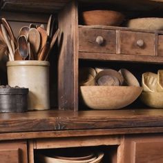 an old wooden cabinet filled with dishes and utensils