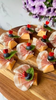 small appetizers are arranged on a wooden platter