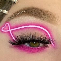 a woman's eye with bright pink makeup and long false eyelashes on her face