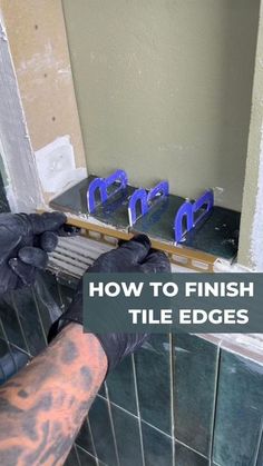 a man in black gloves is fixing tile on a bathroom wall with blue handles and the words how to finish tile edges