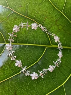 "6MM HONU PLUMERIA STERLING SILVER BRACELET This genuine 925 sterling silver bracelet features the plumeria flower. Plumeria, in Hawaiian culture symbolizes beauty, charm, grace, and new beginnings, or re-birth. It is one of the most popular flowers on the Hawaiian Islands and widely used in lei making and jewelry designs. Makes a great gift or addition to your Hawaiian jewelry collection. Material: 925 STERLING SILVER Length available: 7\" or 7.5\" Diameter of Flower: 6mm Closure: Lobster Clasp Dainty Silver Flower Charm Bracelet, Flower Plumeria, Lei Making, Guitar Jewelry, Silver Flower Bracelet, Tropical Jewelry, Most Popular Flowers, Jewelry Editorial, Popular Flowers