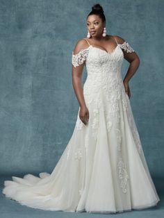 a woman in a white wedding dress posing for a photo with her hands on her hips