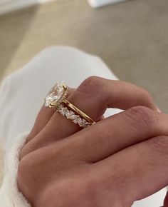 a close up of a person's hand holding a diamond ring