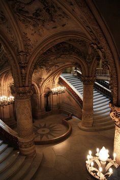 an ornate building with stairs and chandeliers