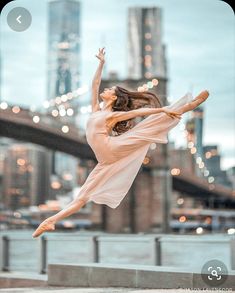 a woman is doing a ballet move in front of a cityscape