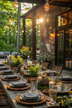 an outdoor dining table set with plates and place settings for dinner outside at dusk, surrounded by greenery