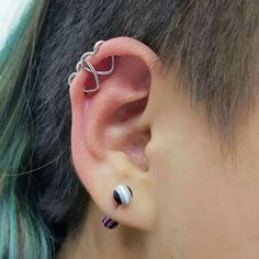 a woman with blue hair wearing an ear piercing