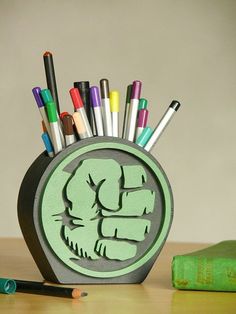 a pen holder with pens and markers in it