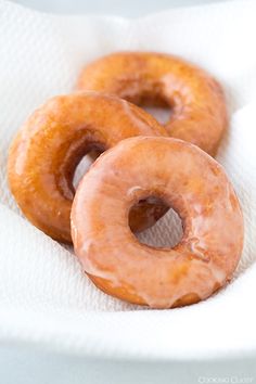 three glazed donuts sitting in a paper towel