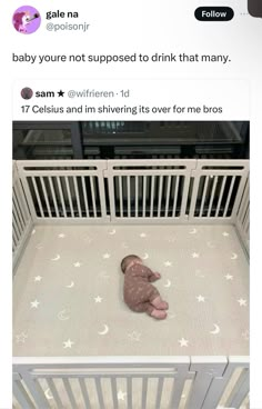 a baby laying in a crib with stars and moon prints on the floor next to it