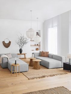 a living room with white furniture and wooden floors