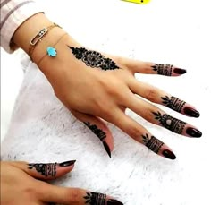 a woman's hand with henna tattoos on it and two hands, both decorated with