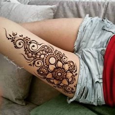 a woman's legs with henna tattoos on them