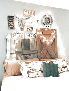 a bed with two pillows on it and some signs above the headboard that are attached to the wall