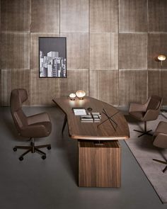 an office desk with two chairs and a large wooden table in front of the wall