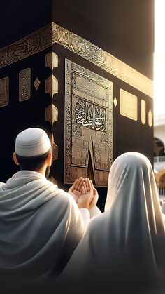 two men are praying in front of the kabab