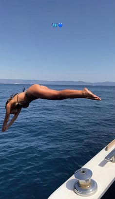 a woman diving into the water from a boat