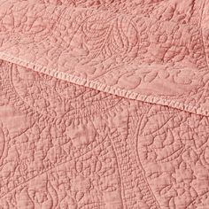 an image of a pink quilted bedding with white stitching on the edges