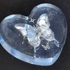 a heart shaped glass box with two butterflies on it