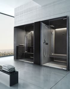 a bathroom with two stalls and a bench in front of the window overlooking the city