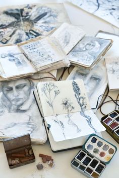 many drawings are spread out on the table