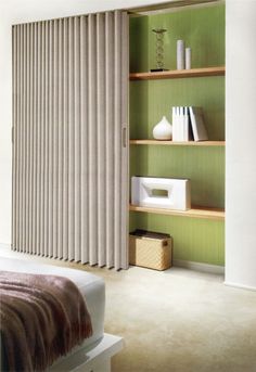 a bed sitting in a bedroom next to a book shelf