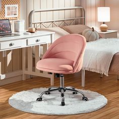 a pink office chair sitting in front of a bed