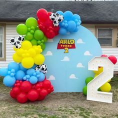 the balloon arch is decorated with soccer balls and numbers 2 to 7 in front of a house