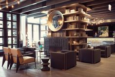 a living room filled with lots of furniture next to a tall book shelf covered in books