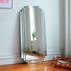 a large mirror sitting on top of a wooden floor