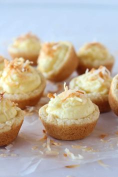 several small cupcakes with coconut on top